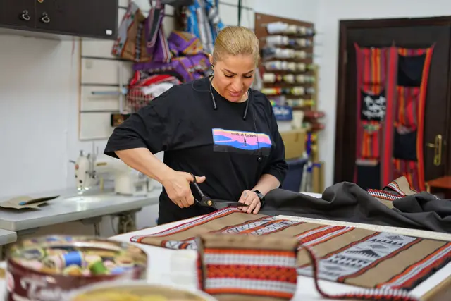 An artisan of The Nun Project with handwoven bags