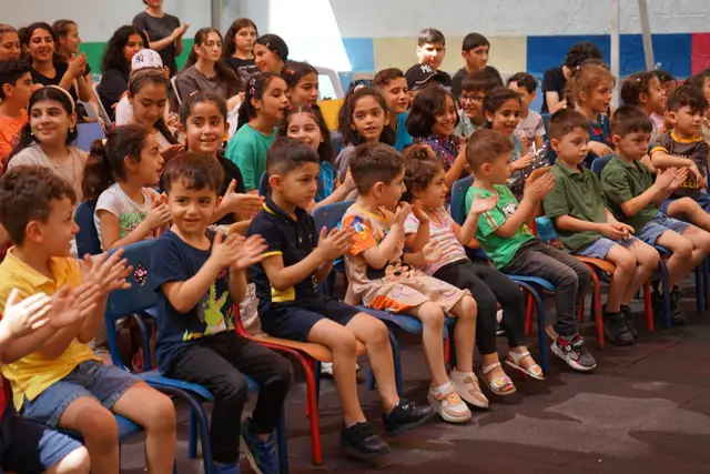 Children raising their hands in a Marka classroom